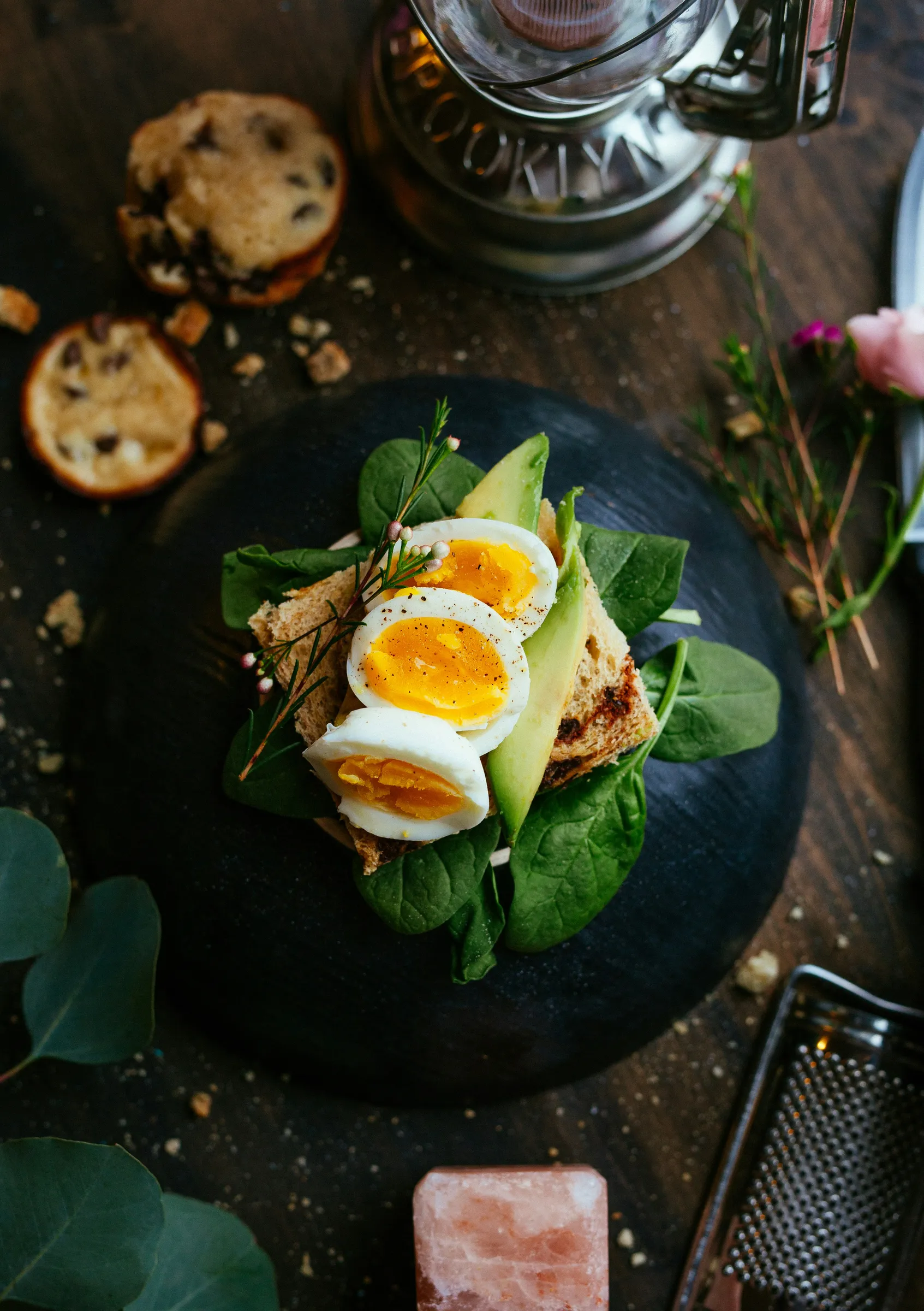 Avocado toast with soft-boiled eggs and spinach on a slate plate, styled for a restaurant menu