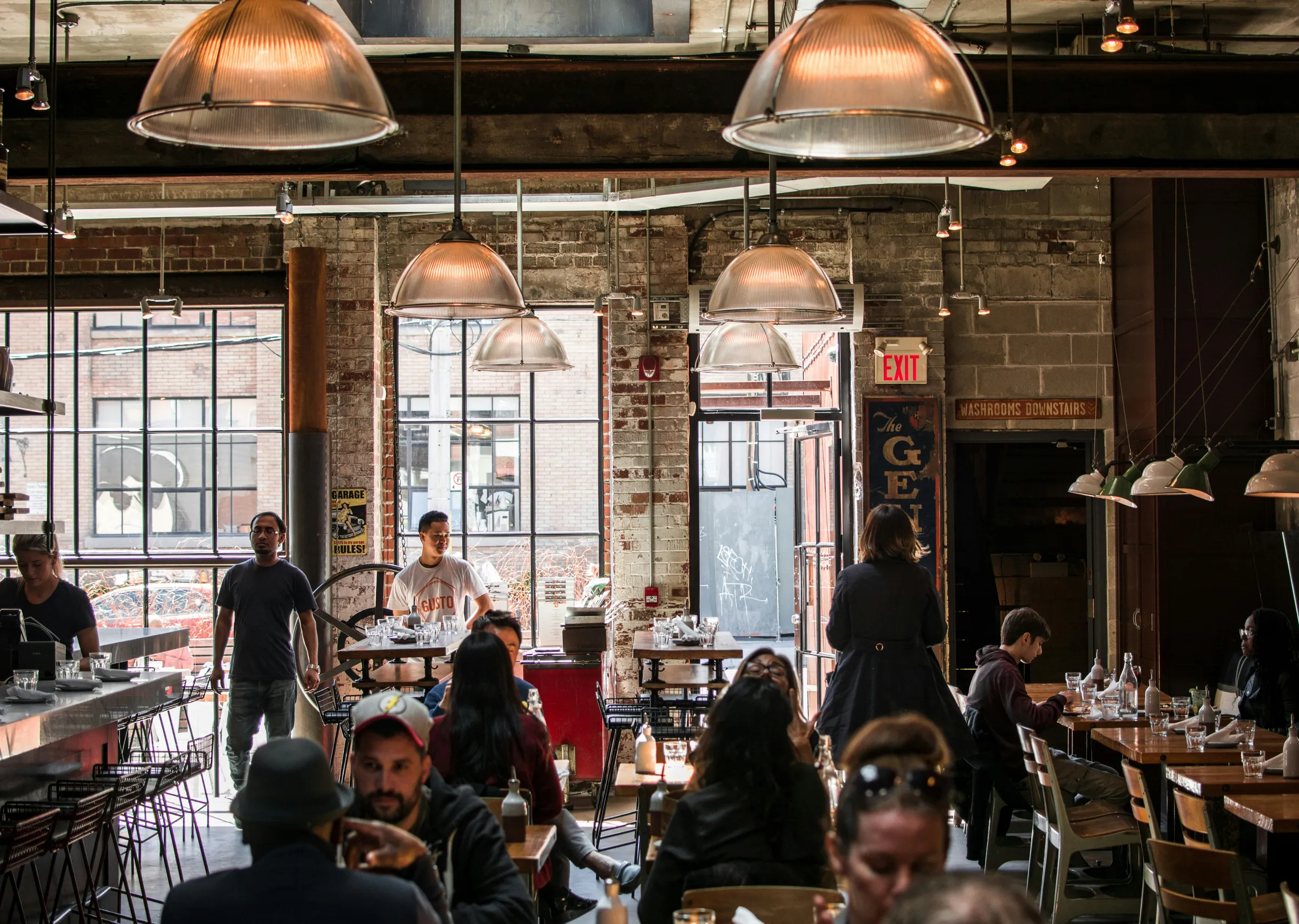 Bustling restaurant interior with exposed brick walls and industrial pendant lighting