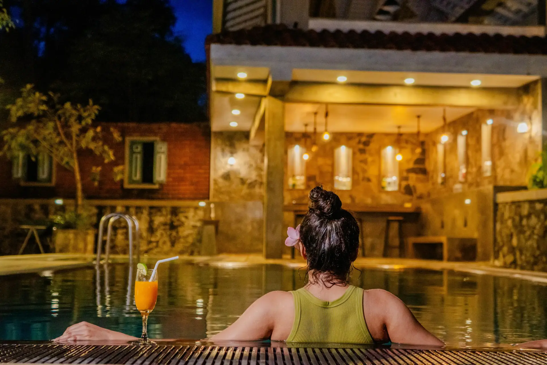 Resort pool at night with a cocktail by the water